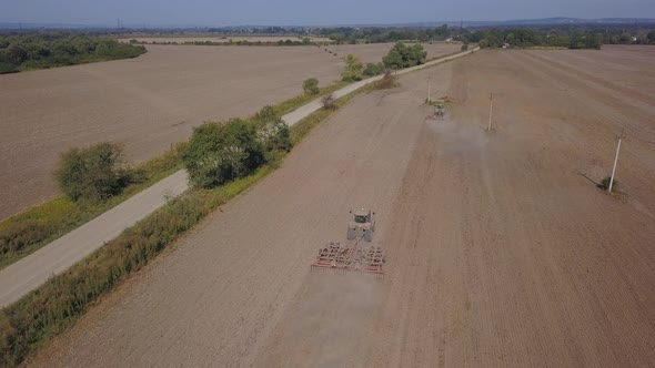 Aerial View. Tractor Cultivates Agricultural Land.