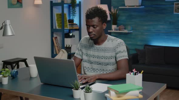 Business Man of African Ethnicity Using Laptop for Online Remote Work alt