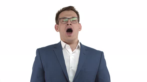 Handsome Male Entrepreneur in Blue Suit and Glasses Feeling Tired Yawning and Covering Opened Mouth alt