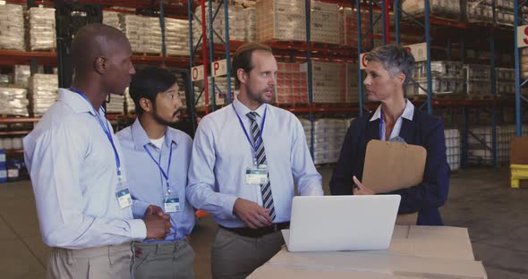Managers and staff talking in a warehouse laoding bay 4k alt
