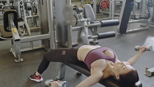 Seductive Sportswoman Doing Dumbbell Flyes alt