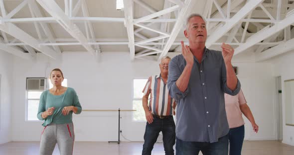 senior male and female friends spending time together in a ballroom and dancing alt