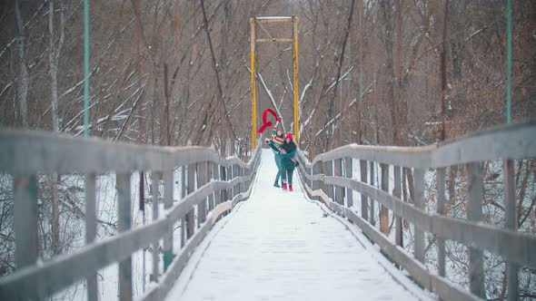 Two Young Women in Colorful Sweaters Having Fun and Playing with Their Scarves alt