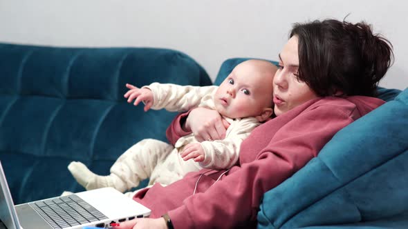 Freelancer Mother Sitting on Couch at Home Office During Lockdown