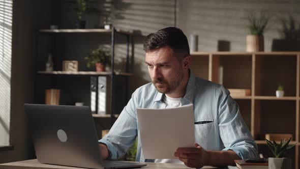 Concentrated Young Businessman Holding Paper Correspondence Reading Letter or Documents Analyzing alt