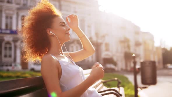 Beautiful Girl Smiling Enjoying Relaxing Sitting on Bench Outside Slow Motion alt