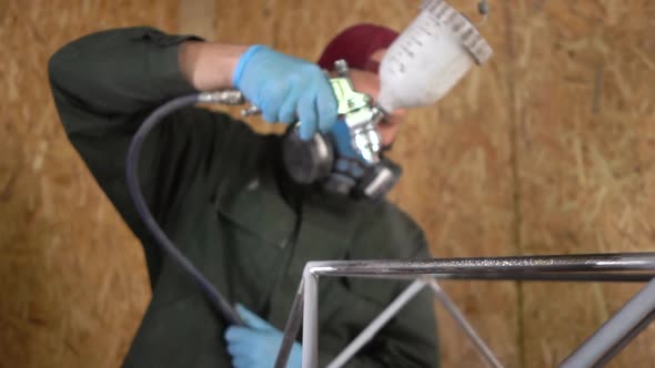 Worker Paints Metal Products With Airless Spray. The Camera Moves From Defocus To Focus. Slowmotion