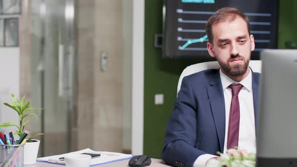 Caucasian Businessman Reads Something on the Screen Then Disagrees alt