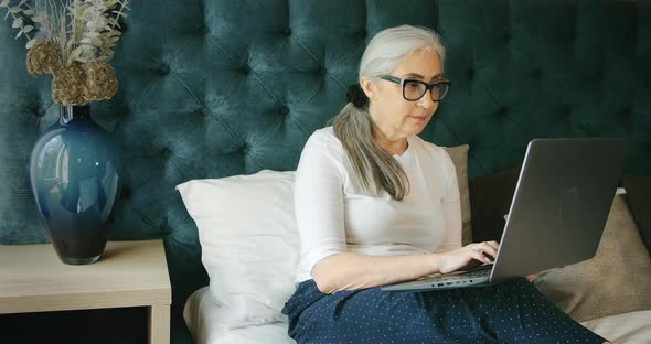 Elderly Woman Indoors with Laptop