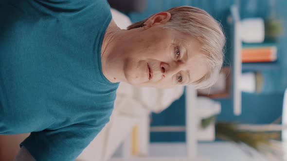 Vertical Video Handheld Shot of Elder Person Using Resistance Band to Exercise alt