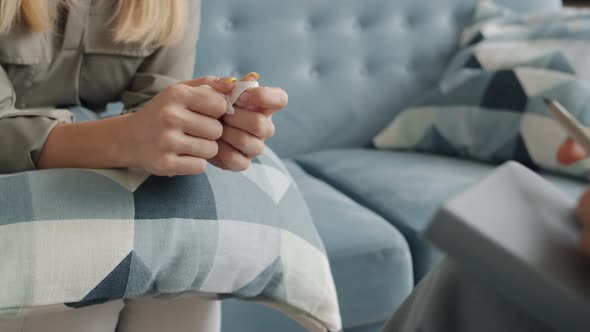 Closeup of Female Hands Holding Tissue While Nervous Woman Talking to Therapist in Office alt