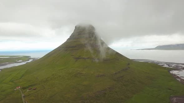 Kirkjufell mountain shrouded in clouds, Iceland. Aerial drone ascendent alt