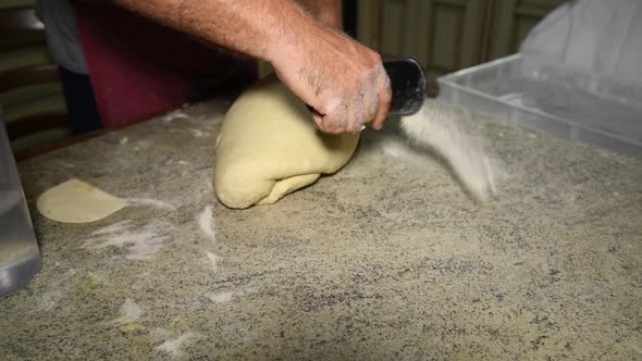 man putting a flour on the stone table to knead the dough for homemande bread alt