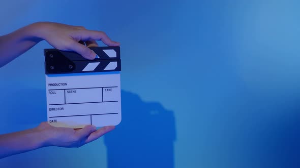 Movie clapperboard footage. Man hand holding film slate and clapping it in studio before shooting