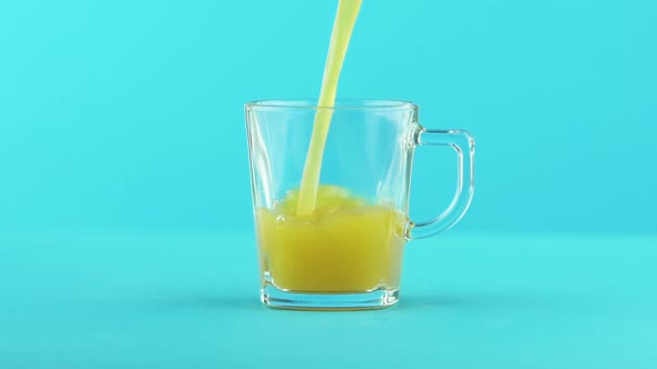 Slow Motion Close-up Shot of Fruit Orange Multifruit Juice Cold Beverage Drink Pooring Into Glass alt