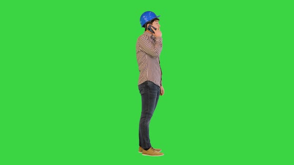 Asian Construction Worker Making a Call on a Green Screen Chroma Key