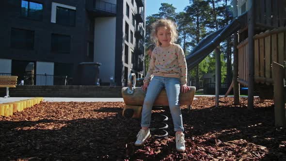 Beautiful Small Girl Play in Playground at Spring alt