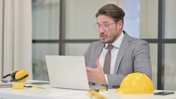 Middle Aged Engineer Talking on Video Call on Laptop in Office alt