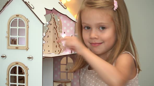 Girl Plays Dollhouse with Toy Furniture