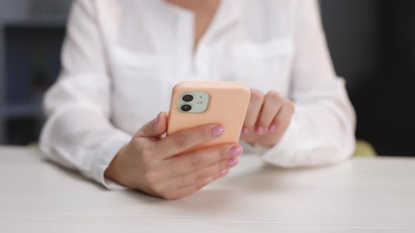 Woman Holds Mobile Phone and Swipes Photos or Pictures Left Indoors of Cozy Home alt