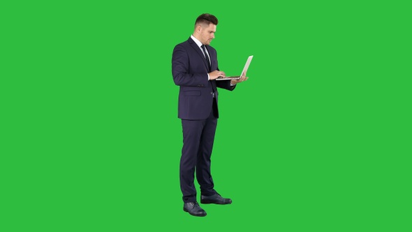 Businessman standing and using laptop on a Green Screen alt