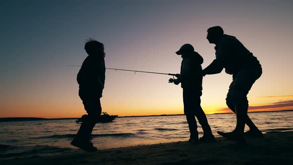 Father Is Helping His Happy Kids To Fish in a Lake alt