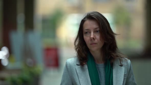 Portrait of a Middle-aged Woman Walking on the Street in Autumn in a Coat. the Woman Smiles at the alt