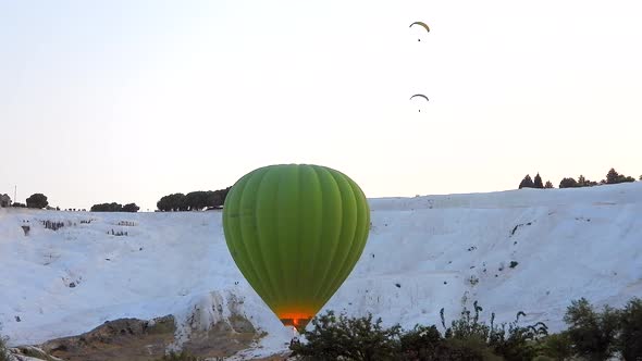 Hot Air Balloons in White Travertines of Pamukkale, a Touristic Natural World Heritage Site