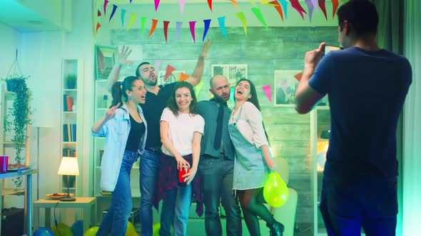 Young Man at a Party Taking Photos of His Friends alt