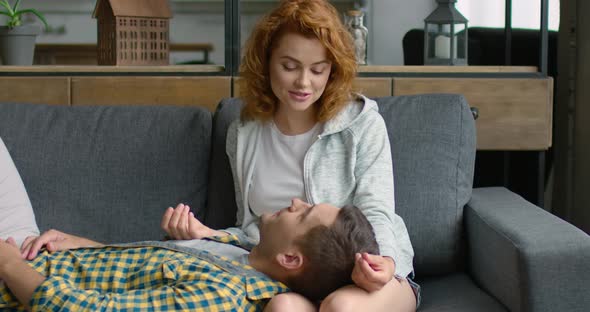 Young Couple in Love Is Lying on Sofa at Home, Enjoying Their Relationships alt