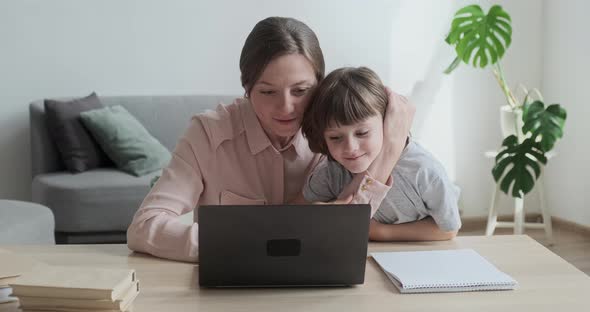 Mom and Son Using the Laptop Together Surfing the Internet Shopping and Playing Games
