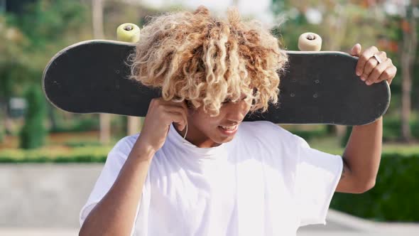 Teenager Listening Music With Skateboard