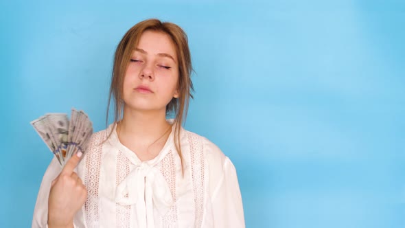 Attractive brunette Caucasian young woman 20 years of age holds a fan of dollar bills in her hands a alt