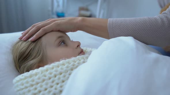 Sick Female Kid in Scarf Lying in Bed, Looking at Mom Giving Teddy Bear Epidemic