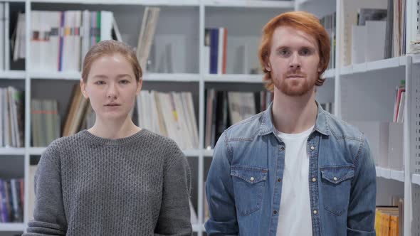 Portrait of Young Man and Woman Looking in Camera Team alt
