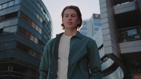 Young Man in Casual Wear Posing on Street of Big City alt