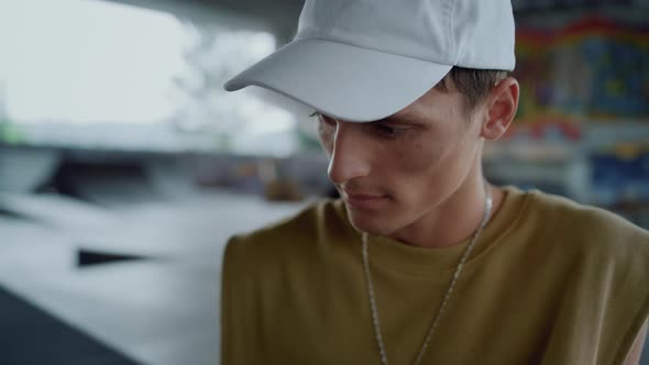 Joyful Guy Reading News on Mobile Phone at Skate Park alt