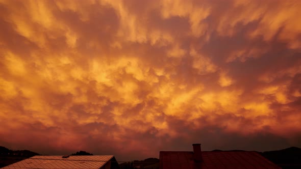 Beautiful Fiery Clouds After a Storm of Lighting in the Setting Sun Over the Roofs of Houses
