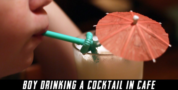 Boy Drinking A Cocktail In Cafe alt