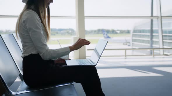Young Pretty Woman Printing on Laptop Sitting at Airport alt