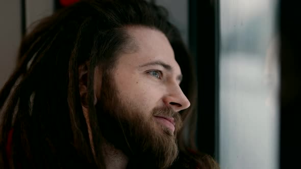 Closeup Portrait of a Handsome Homosexual Man in a City Transport Train Car Looking Out the Window alt