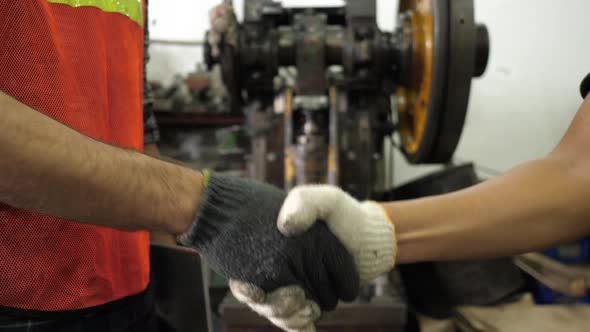 Closeup handshaking boss and engineer foreman after complete job with tablet