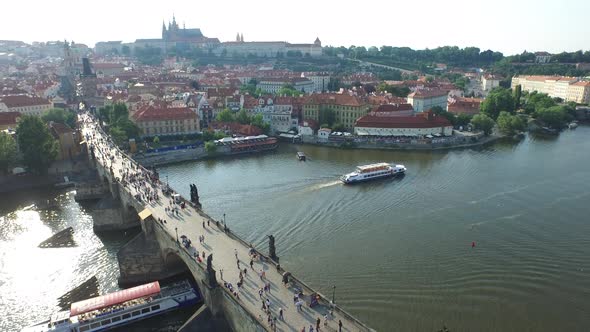 Aerial view of Vltava River with two boats and bridge