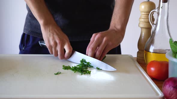 Fresh Spring Onion Sliced In White Chopping Board By Sharp Knife. - High Angle Shot alt