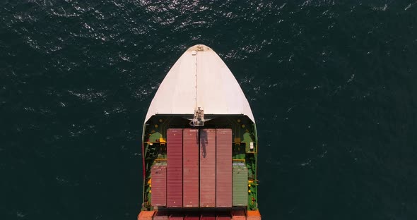 Shipping containers stacked on a sailing Container ship, Top down shot. alt
