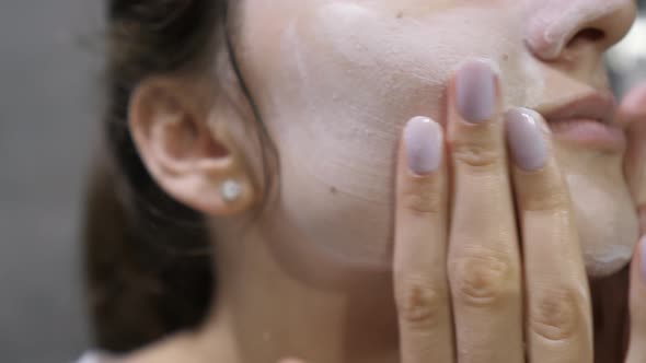 Use of Foam to Cleanse Female Face Closeup