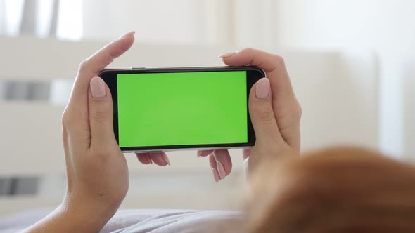 Female in bed with green screen display gadget close-up 4K 2160p 30fps UltraHD footage - Smartphone  alt