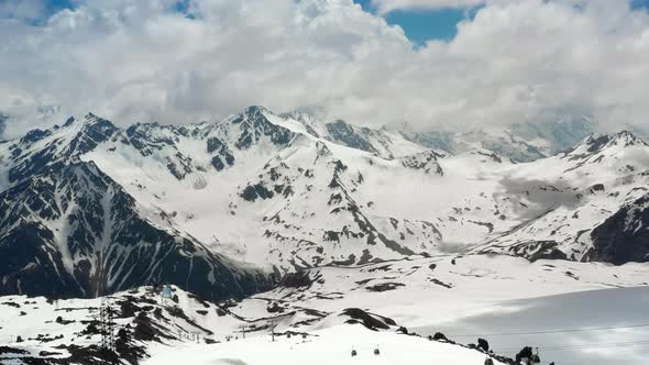 Air Flight Through Mountain Clouds Over Beautiful Snowcapped Peaks of Mountains and Glaciers alt