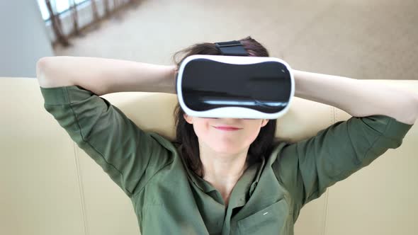 High Angle Portrait of Smiling Young Woman Putting on Modern Virtual Reality Glasses alt