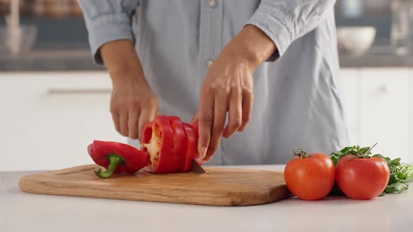Close Up Footage of Female's Hands Slicing Red Pepper to Make Salad with Tomatoes in Slowmotion alt